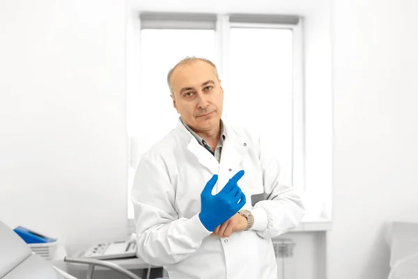 患者を調べる前に医療用手袋を着用した泌尿器科医の肖像 — ストック写真