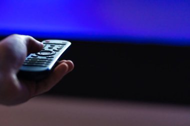 Evde boş vakit geçirmek. Televizyon seyret. Uzaktan kumanda yakın planda.