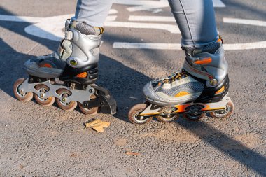 Aktif boş zaman. Sportif bir kız sonbahar parkında paten kayıyor..