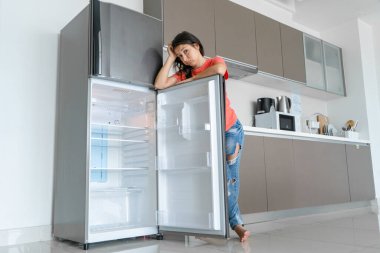 Kız boş buzdolabına şaşırdı. Yiyecek eksikliği. Yemek teslimatı.