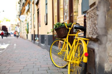 Cityscape of the old cozy European city. A flower pot from an old bicycle. clipart