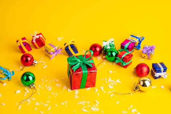 黄色の背景にクリスマスプレゼント付きのギフトボックス 新年の装飾の中で — ストック写真