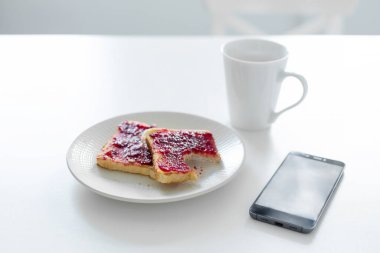 Kahvaltınız masada. Telefonun yanında kiraz reçelli bir fincan kahve ve tost..