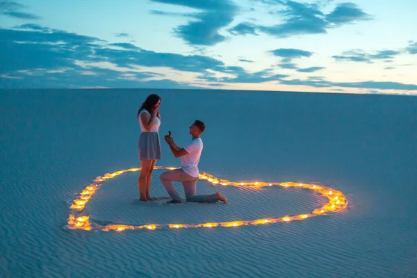 恋爱中的情侣在沙滩上拥抱浪漫 浪漫的气氛 在沙滩上燃烧着心形的蜡烛 — 图库照片