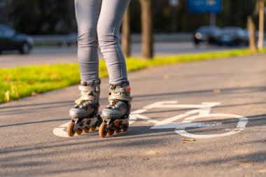 Aktif boş zaman. Sportif bir kız sonbahar parkında paten kayıyor..