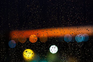 Pencerelere su damlaları ve günbatımında şehir batımları.