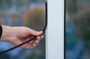 Pencerelerin onarımı ve kurulumunda profesyonel usta, pvc pencerelerindeki lastik contaları değiştirir.