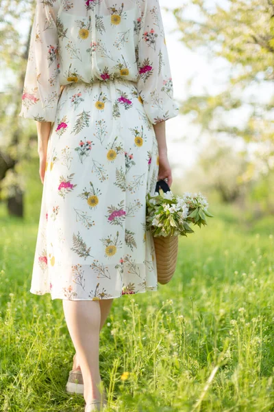 春の緑の公園を歩いている女の子が咲く自然を楽しんでいる — ストック写真