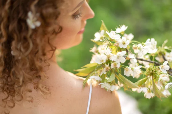后视镜一个美丽娇嫩的女孩 卷发白花 手里拿着一枝开花的枝条 春天和夏天的灵感 化妆品概念 — 图库照片