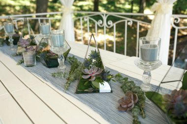 Taze sulu ve gül çiçekli Floraryum şenlik masası süslemesi. Olay taze çiçek süslemesi. Çiçekçi iş akışı. Düğün töreni tasarımı.