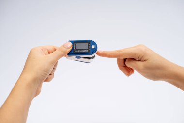 Fingertip Pulse Oximeter on finger. On white background. Device for self health diagnostic. clipart