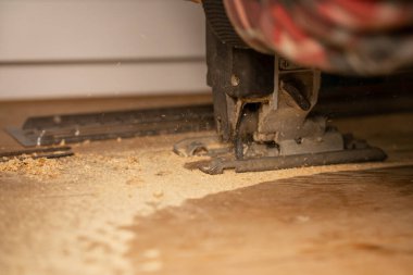 Ahşap işleme. Tahta tahtayı elektrikli testereyle kesen kişi.