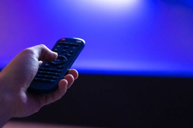 Evde boş vakit geçirmek. Televizyon seyret. Uzaktan kumanda yakın planda.