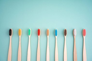 Açık yeşil arka planda bambu ağacından yapılmış çevre dostu antibakteriyel diş fırçaları. Çevresel bakım eğilimleri.