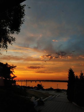 Doğa manzarası. Suyun üzerinde gün batımı, güneşin yansıması ve sudaki bulutlar..