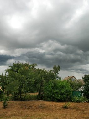 Köydeki tarlanın üzerinde bulutlu bulutlu bir gökyüzü. Doğal manzara..