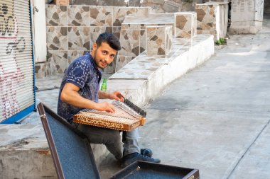 İstanbul sokaklarında para kazanmak için Kanun 'da müzik çalan genç bir sanatçı. Türkiye, İstanbul - 21.07.2020