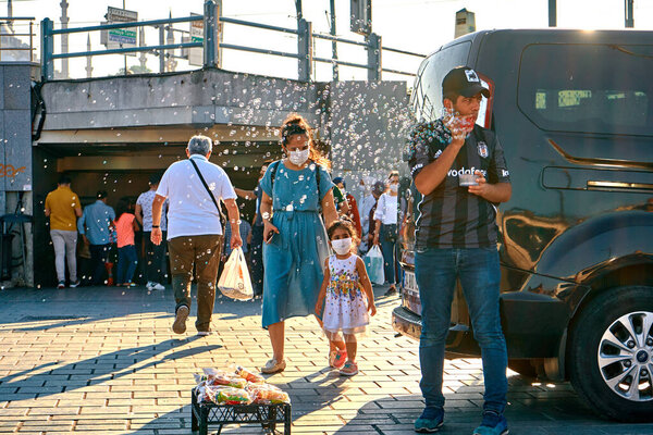 Turkish street vendor take attention to his stuff use soap bubbles. Turkey , Istanbul - 21.07.2020