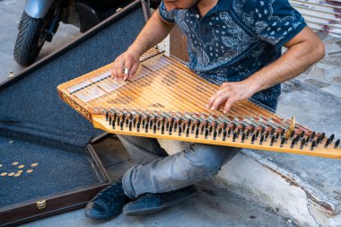 İstanbul sokaklarında para kazanmak için Kanun 'da müzik çalan genç bir sanatçı. Türkiye, İstanbul - 21.07.2020