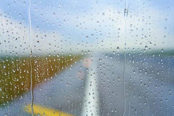 View through the foggy glass of an airplane before takeoff on a rainy day.