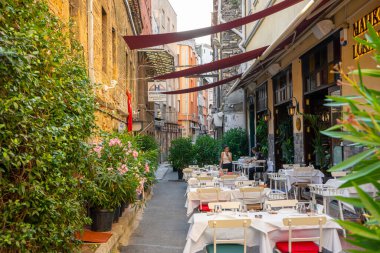 Lokanta masalarıyla dolu dar bir sokak. Dar bir caddedeki restoranın yaz bölgesi. Türkiye, İstanbul - 21.07.2020