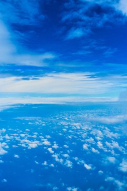 Koyu mavi gökyüzünde kabarık beyaz bulutların manzarası. Yüksek irtifadaki uçaktan görüntüle.