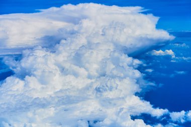Koyu mavi gökyüzünde kabarık beyaz bulutların manzarası. Yüksek irtifadaki uçaktan görüntüle.