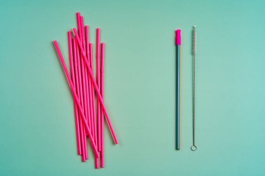 Çevreyi korumaya yönelik modern eğilim. Bir paket pembe plastik içecek pipetine karşı temizleme fırçalı tekrar kullanılabilir bir içecek pipeti..
