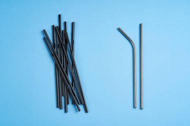 Çevreyi korumaya yönelik modern eğilim. Bir paket siyah plastik içecek pipetine karşı sadece iki tane yeniden kullanılabilir metal içecek pipeti..