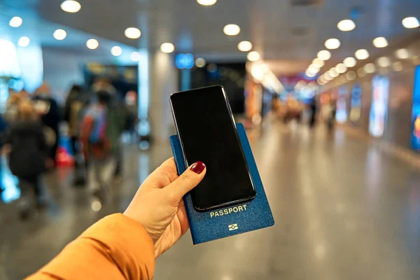 Hand Håller Smartphone Och Ett Pass För Utlandsresor Mot Bakgrund — Stockfoto