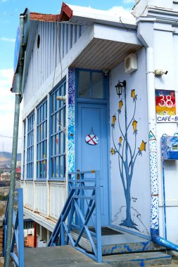 Tiflis 'in eski kısmının mimarisi. Yerel barın ahşap verandasına açılan dar kapı. Tiflis, Gürcistan - 03.16.2021