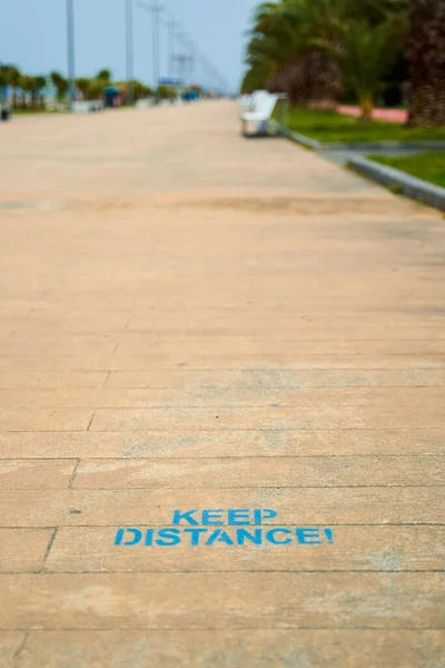 地板上的题词提醒人们保持距离 人行道上的小径 — 图库照片
