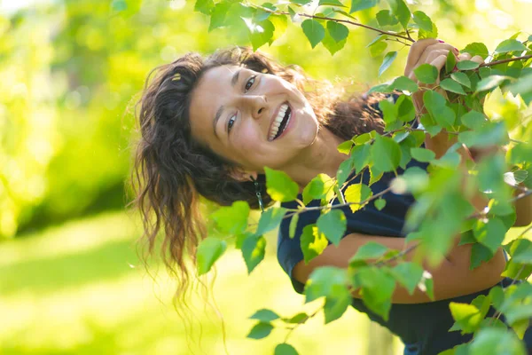 若い美しいブルネットの肖像画は緑の夏の公園で歩くことを楽しむ — ストック写真