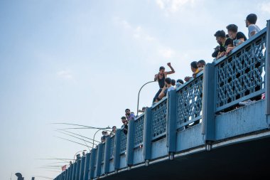 Kalabalık Galata Köprüsü 'nde duruyor ve insanların köprüden suya atlamasını izliyor. Türkiye, İstanbul - 21.07.2020