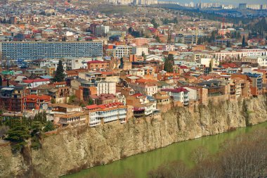 Tiflis 'in eski mimarisi. Nehir kıyısındaki bir uçurumun kenarında yoğun bir yerleşim yeri inşaatı.