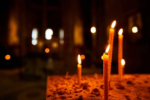 Burning candles in a church on a dark background. Memorial Candles. Burning Candles In The Temple, Sacred Fire. Candles Burning in Dark Church.