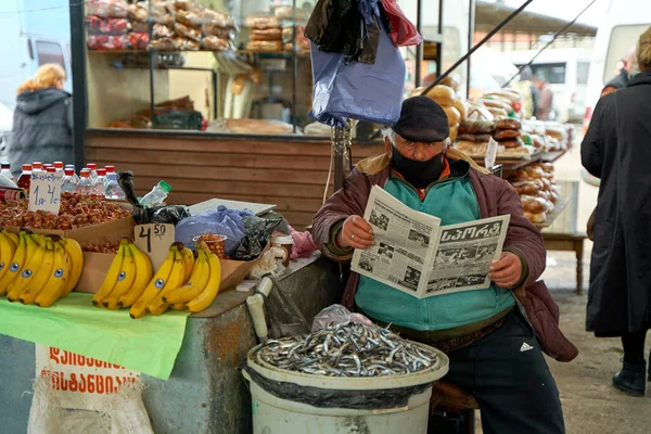 Overweight Georgian Man Street Market Seller Reads Newspaper While Sitting — Stock Photo, Image