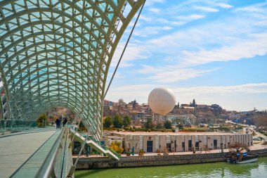 Cam ve metalden yapılmış modern stil tasarımı, Tiflis 'teki Kura Nehri üzerindeki yaya köprüsü. Tiflis, Gürcistan - 03.17.2021
