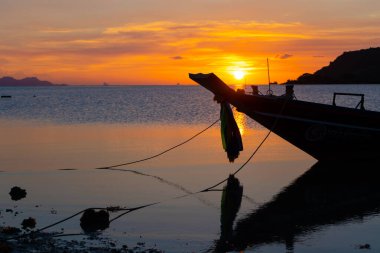 Tayland 'da tropik bir adanın sahilinde güzel bir gün batımı, okyanusta bir teknenin silueti. samui , tailand - 02.24.2020