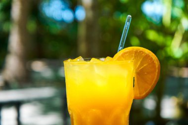 Bir bardak taze sıkılmış, buzlu portakal suyu..