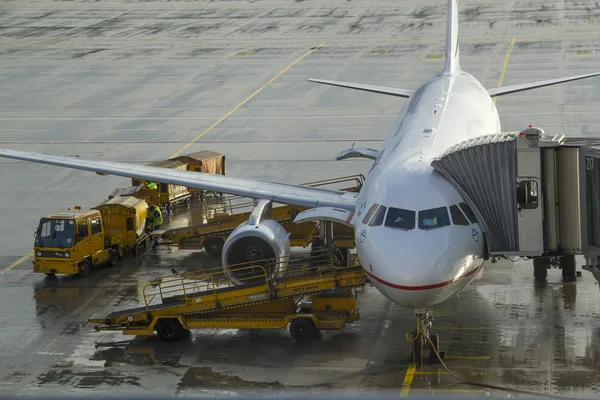 Ground crew refueling and working below a passenger airplane. — Stock Photo, Image