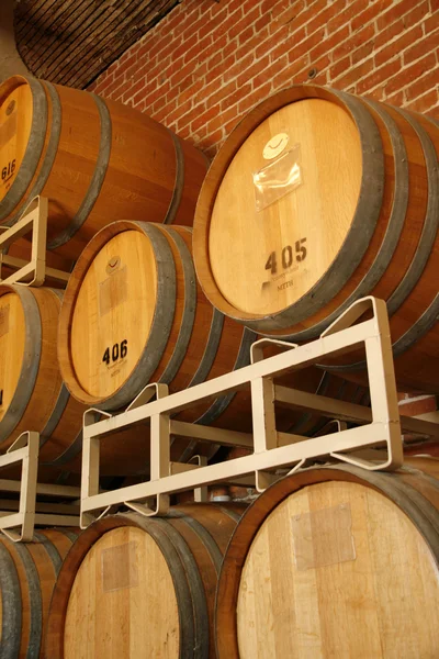 Wine barrels stacked in cellar area of vinery — Stock Photo, Image