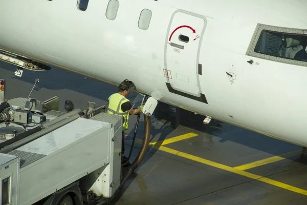 Ground crew refueling and working below a passenger airplane. — Stock Photo, Image