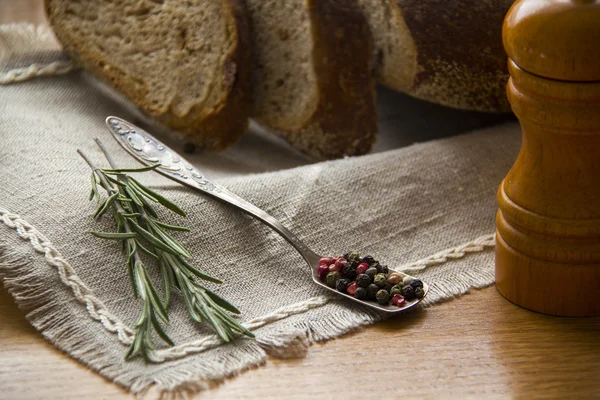 Especias - Rosmary y pimienta en la mesa con molino de pimienta y pan — Foto de Stock