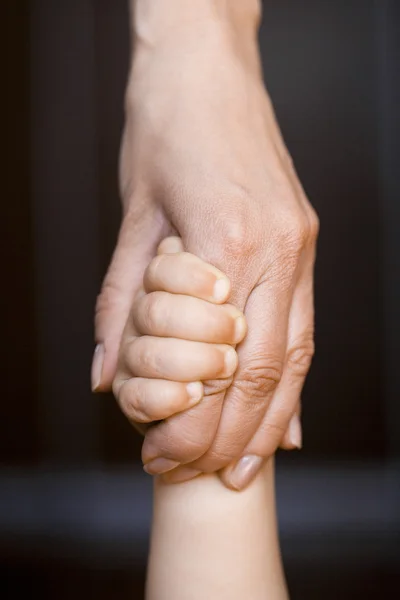 A mão de crianças está em uma mão mãe — Fotografia de Stock