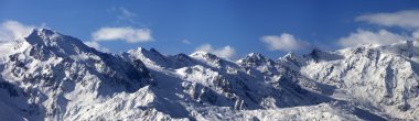 Panoramic view on snowy mountains in sunny day clipart