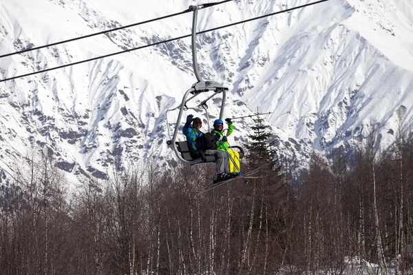 Skiërs familie op stoeltjeslift op mooie zonnige dag — Stockfoto