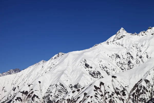 Picos de montanha de neve e céu azul claro — Fotografia de Stock