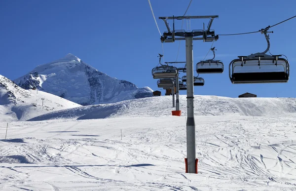 Elevador de cadeira em montanhas nevadas no belo dia de sol — Fotografia de Stock