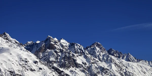 Vista panorâmica em rochas nevadas e céu azul claro, em dia de sol bonito Fotos De Bancos De Imagens Sem Royalties